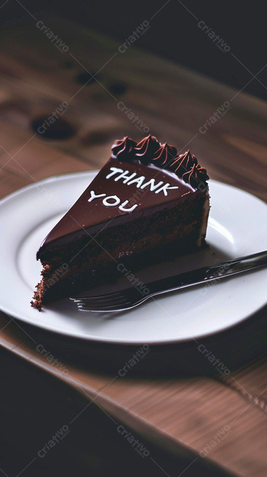 Fatia de bolo de chocolate com mensagem "THANK YOU" em prato branco e garfo