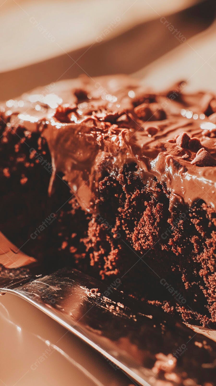 Fatia de bolo de chocolate com cobertura cremosa e gotas de chocolate