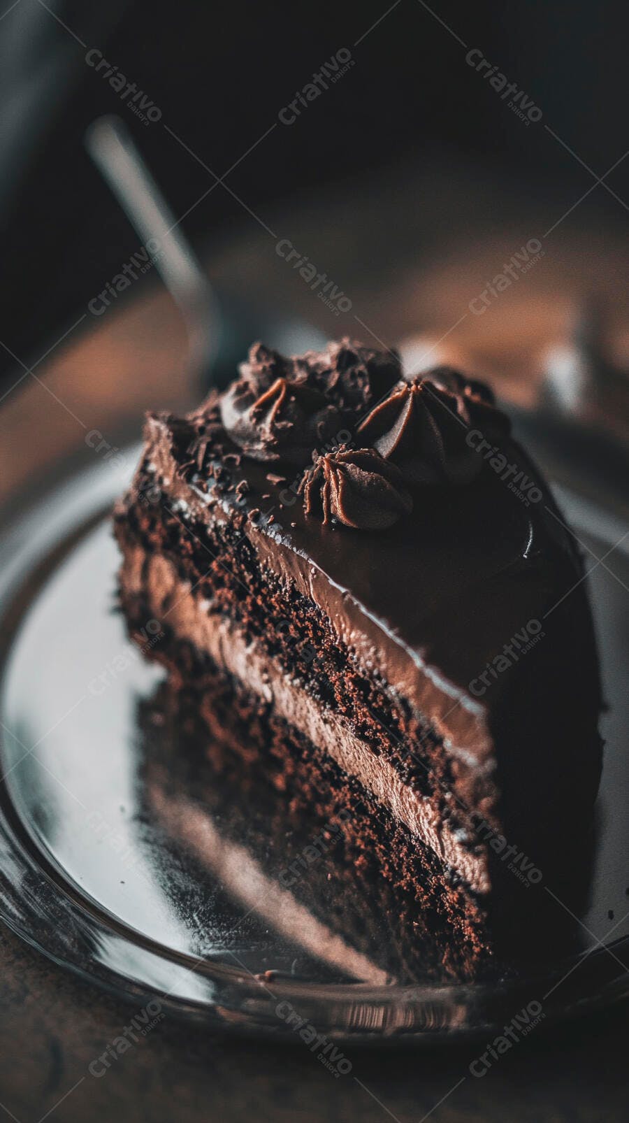 Fatia de bolo de chocolate rico com camadas e ganache em prato prateado