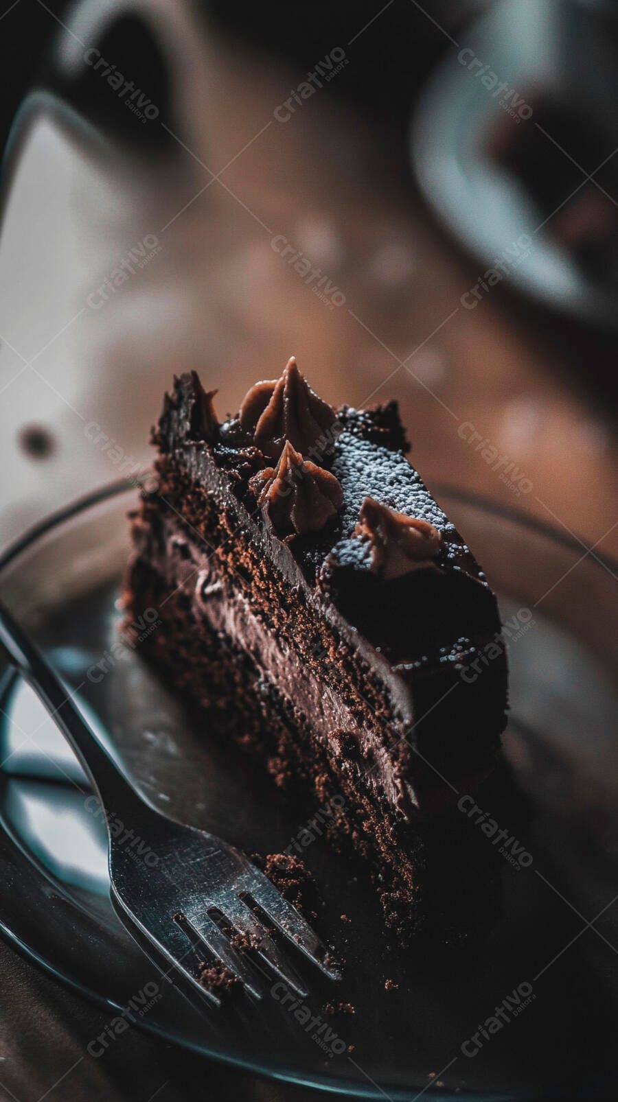 Fatia de bolo de chocolate rico com cobertura e garfo em ambiente escuro