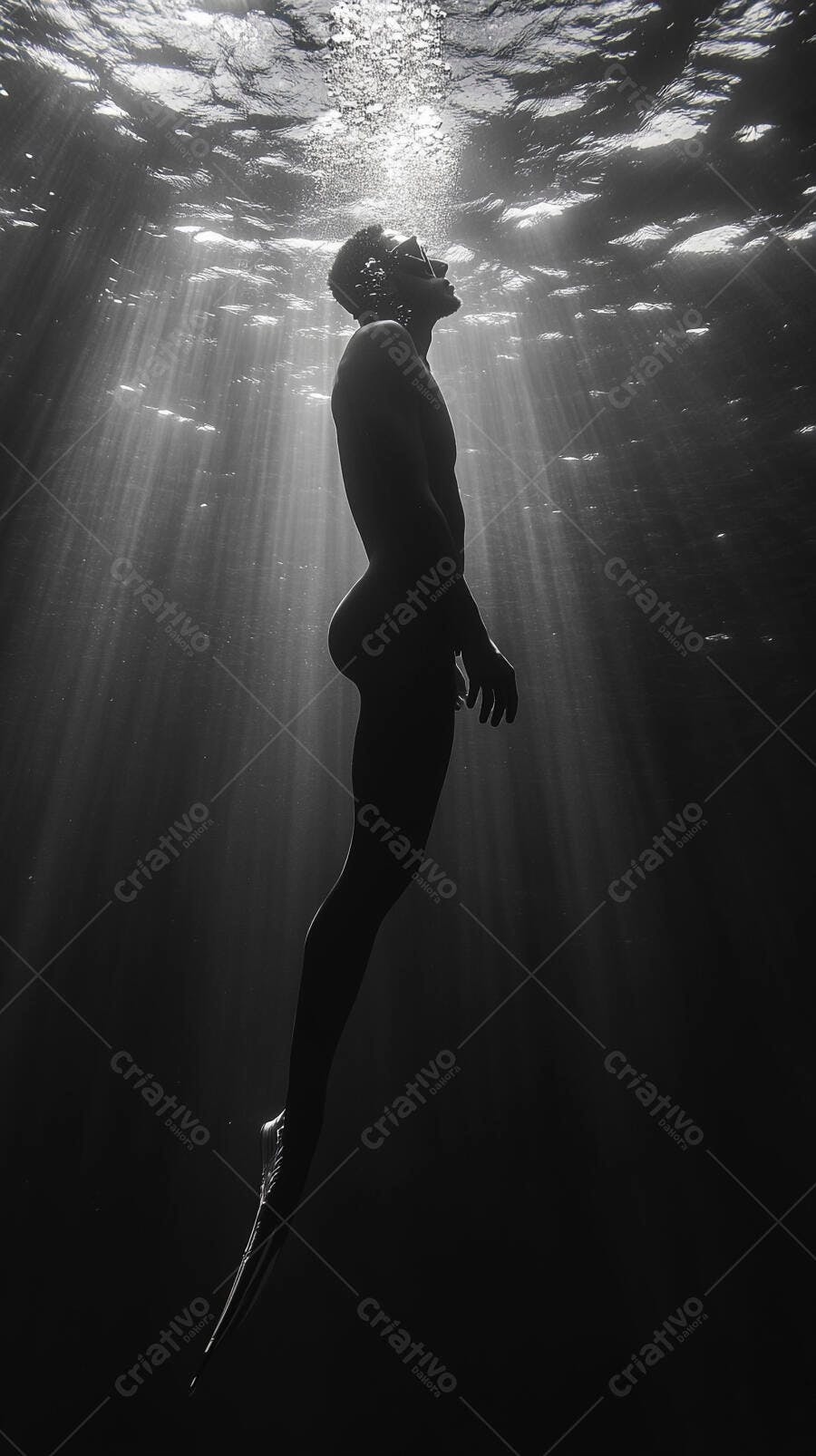 Homem mergulhador com máscara e nadadeiras em águas profundas submerso pela luz