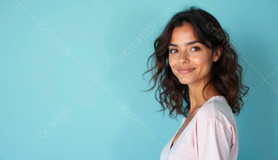 Mulher jovem sorridente de blusa rosa em fundo azul vibrante