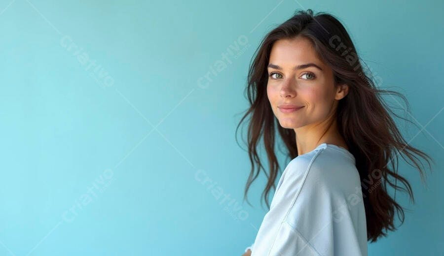 Mulher jovem sorrindo com cabelo solto em fundo azul claro