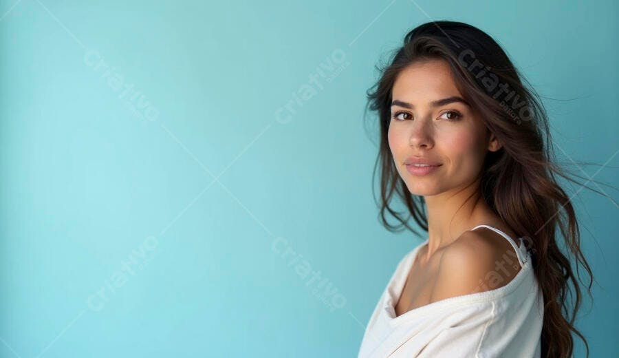 Mulher jovem de cabelo castanho sorrindo em fundo azul claro