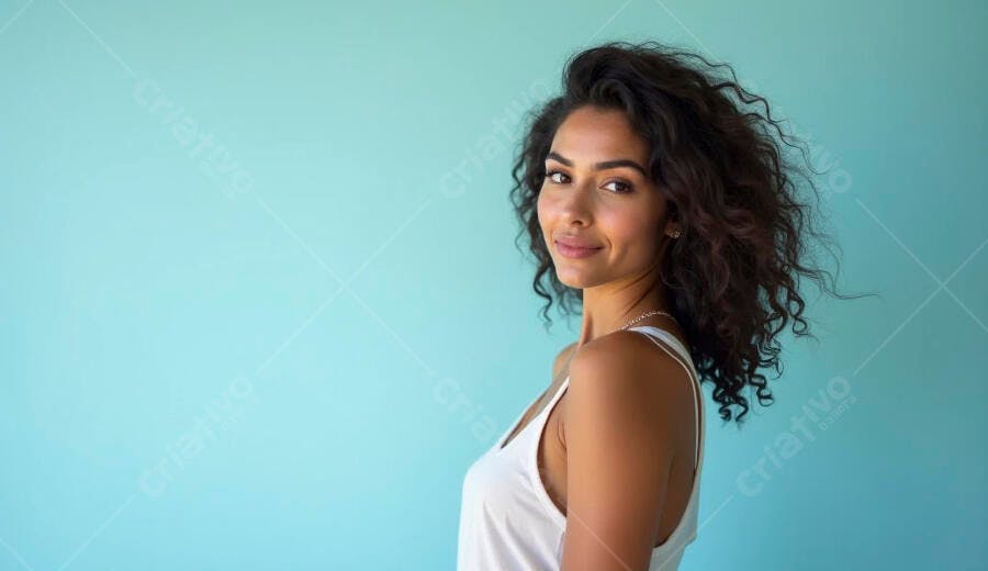 Mulher morena jovem sorrindo com cabelo cacheado em fundo azul claro