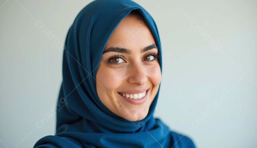 Mulher do Oriente Médio sorridente com hijab azul alegre em fundo claro