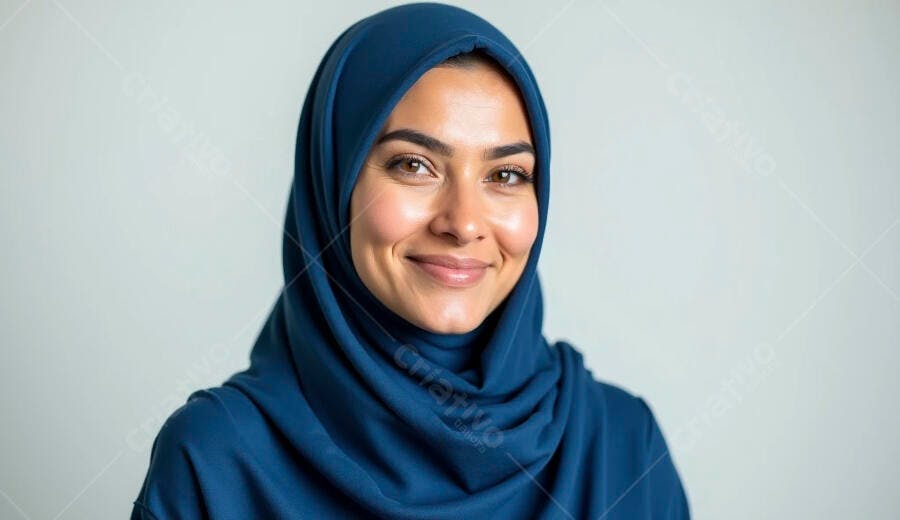 Mulher muçulmana jovem com hijab azul marinho sorrindo em estúdio