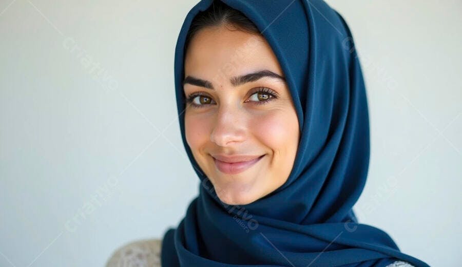Mulher muçulmana sorrindo com hijab azul em estúdio claro