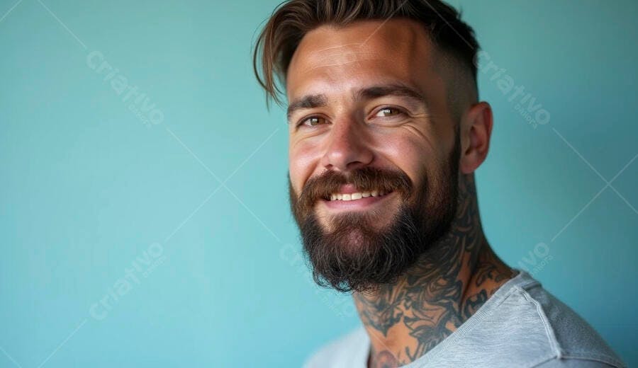 Homem barbudo sorridente com tatuagens em fundo azul moderno