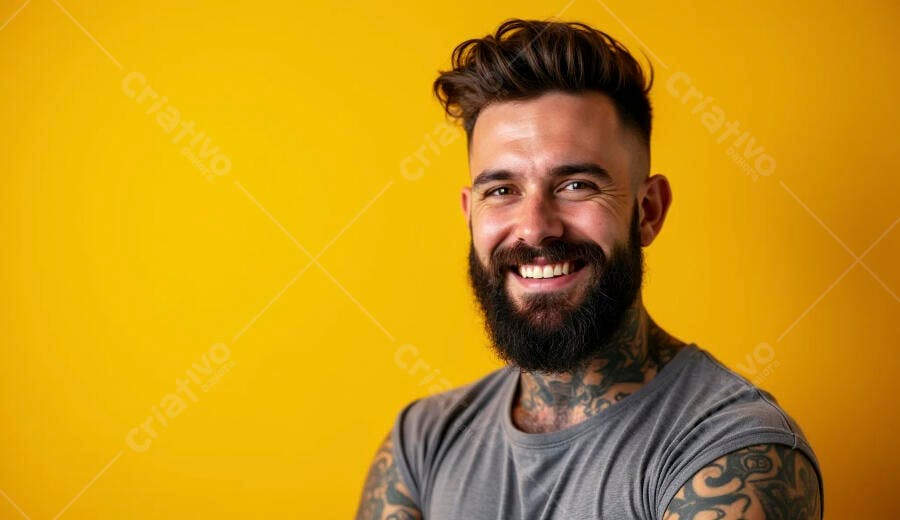 Homem barbudo sorrindo com tatuagens em fundo amarelo vibrante