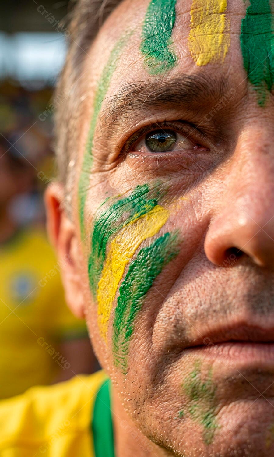 Homem torcedor com rosto pintado em verde e amarelo celebrando o Brasil