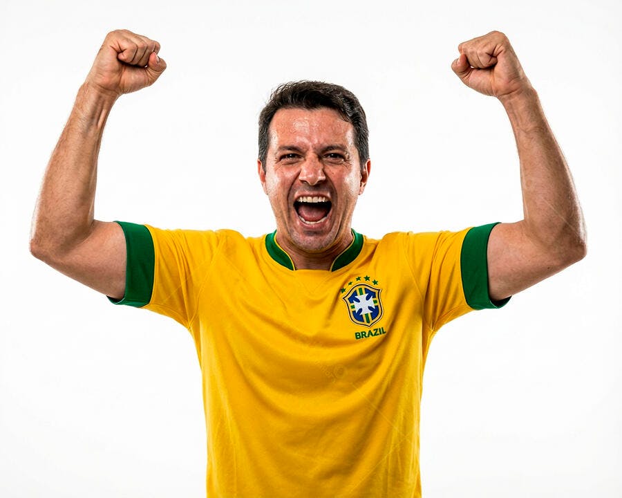 Homem latino torcedor do Brasil celebrando vitória com camisa amarela e verde
