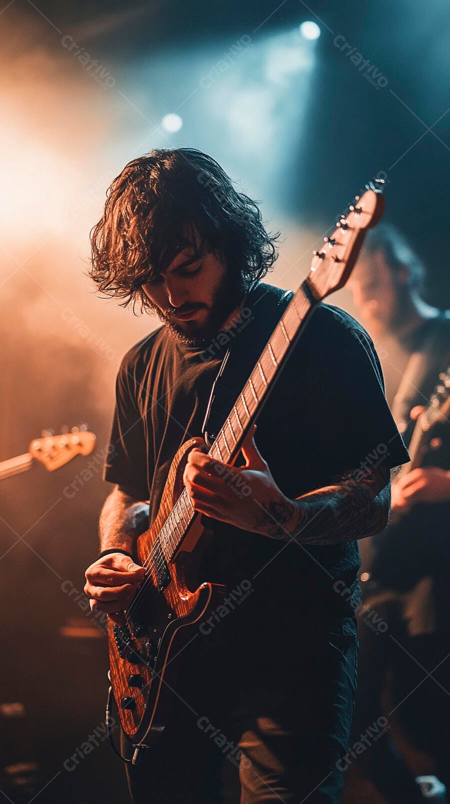 Guitarrista homem barbudo tocando guitarra elétrica em show com luzes laranja e azul