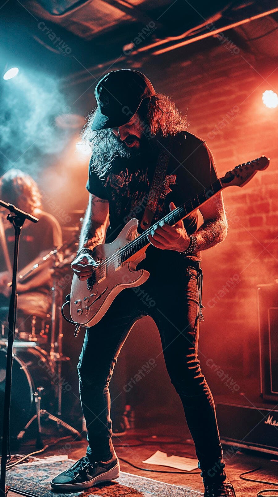 Homem guitarrista barbudo com boné em show de rock com luzes vermelhas e azuis