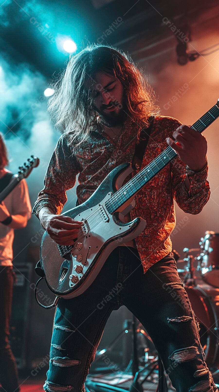 Guitarrista homem de cabelo comprido tocando guitarra elétrica no palco com luzes azuis e laranjas