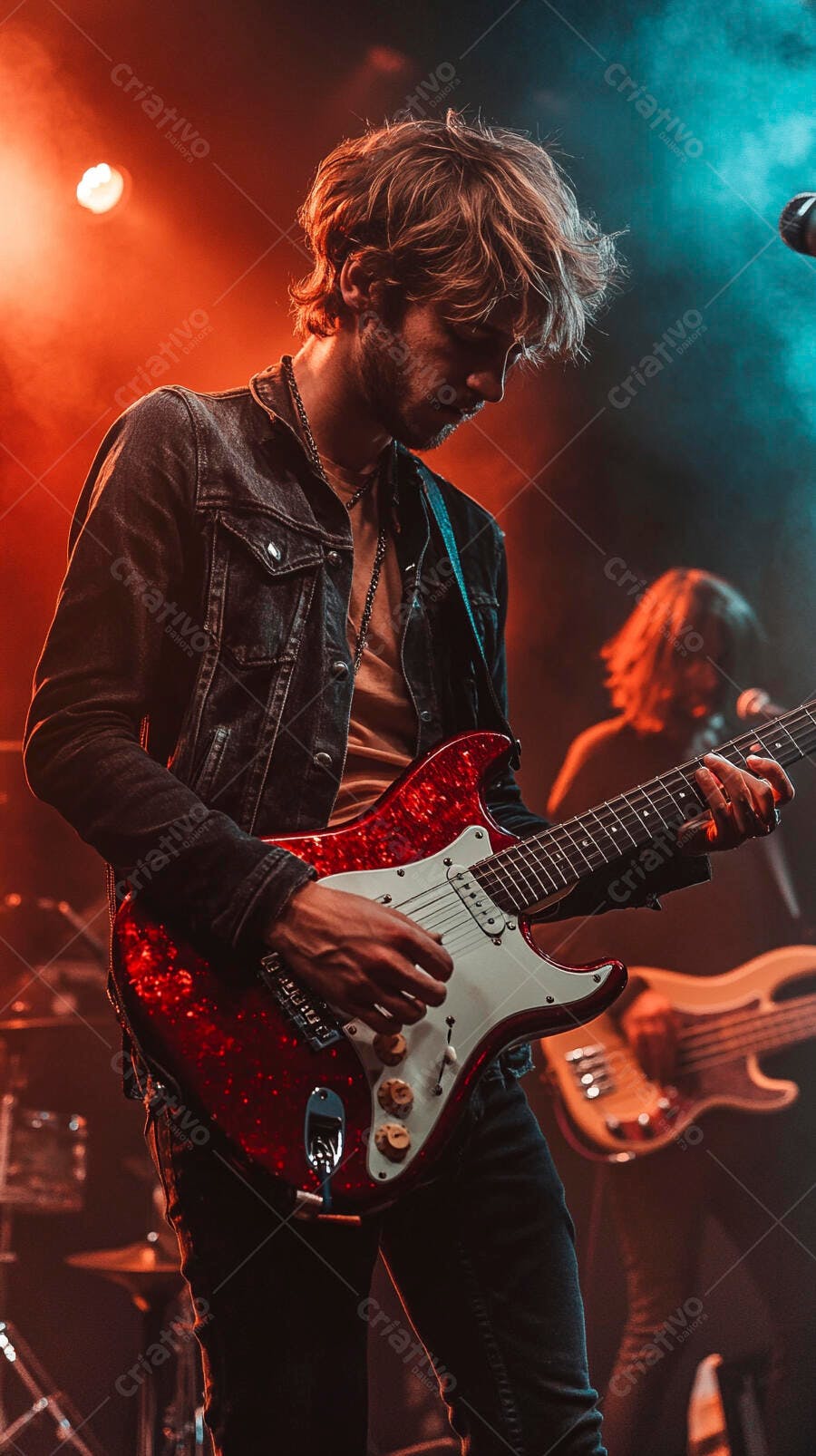 Guitarrista masculino jovem tocando guitarra elétrica vermelha em show ao vivo