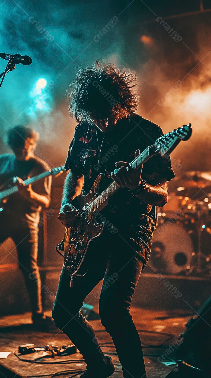Guitarrista com cabelo despenteado tocando guitarra elétrica em palco iluminado com neon laranja e azul