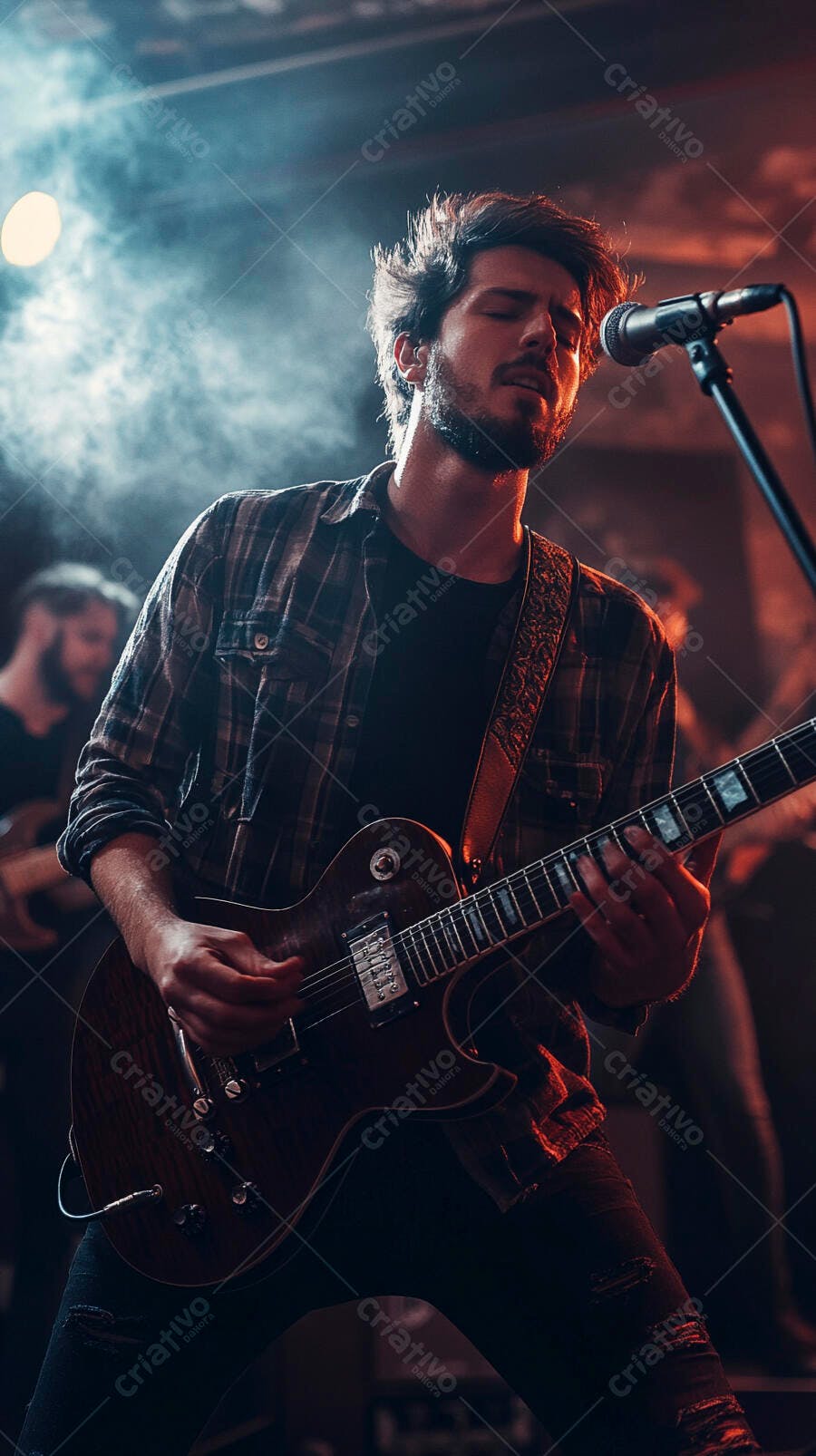 Homem músico barbudo tocando guitarra elétrica no palco com luzes dramáticas vermelhas