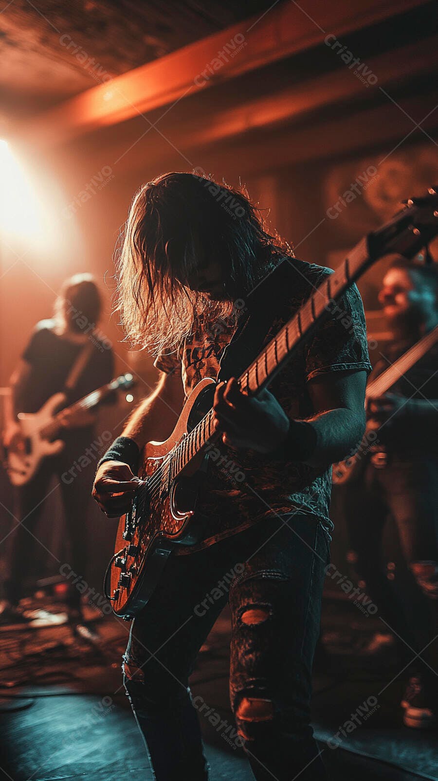 Homem guitarrista de cabelo comprido tocando rock no palco com luzes laranja