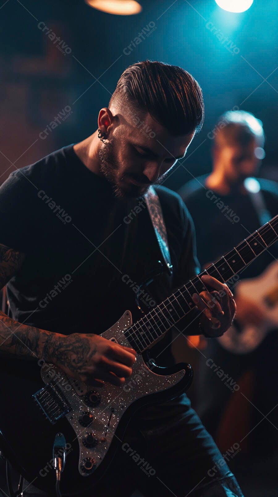 Guitarrista barbudo tocando guitarra elétrica preta em show ao vivo