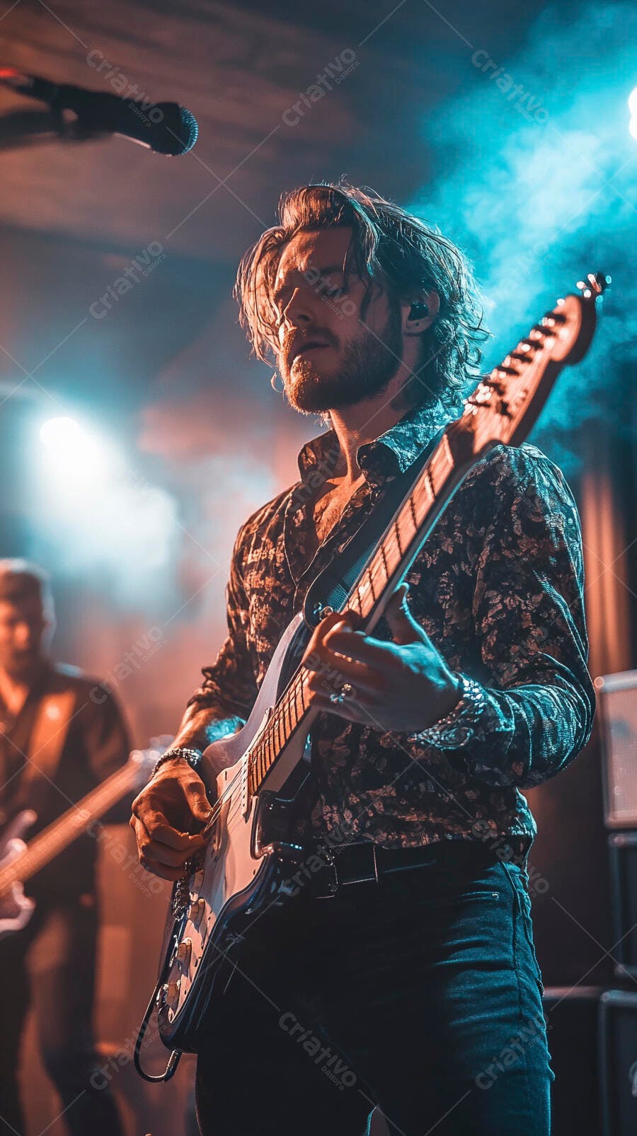 Homem guitarrista barbudo tocando guitarra elétrica branca em palco iluminado neon