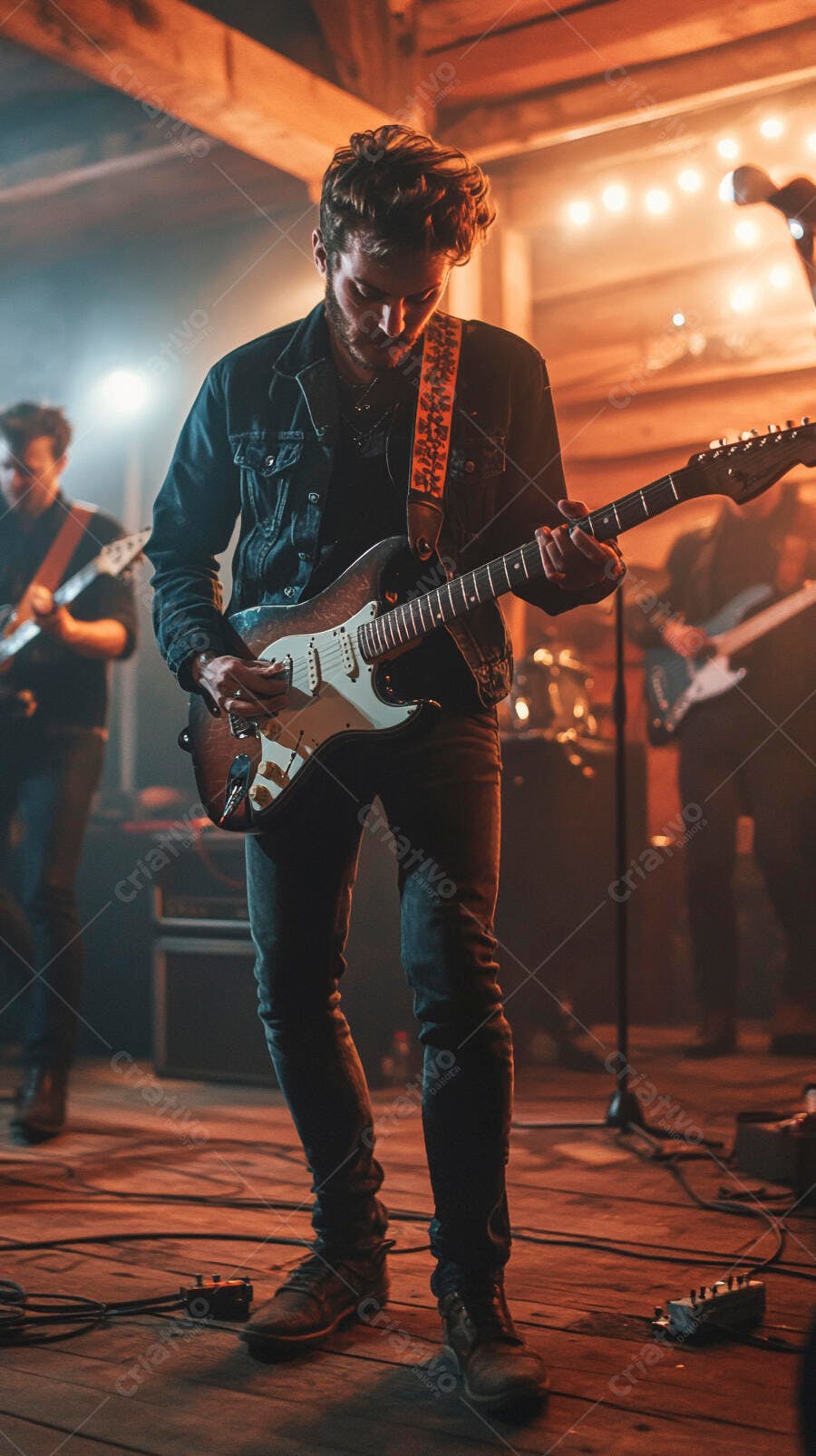 Jovem guitarrista barbudo caucasiano tocando guitarra elétrica em palco quente
