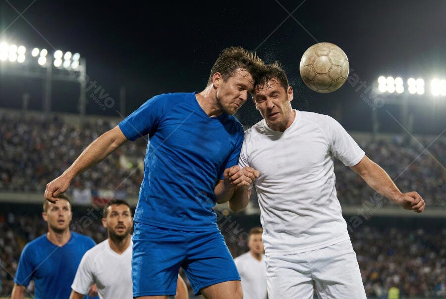 Foto Jogadores de Futebol Cabeceando Bola Partida Noturna