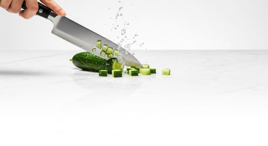 Foto Mão Cortando Pepino com Faca Profissional Salpicos Água